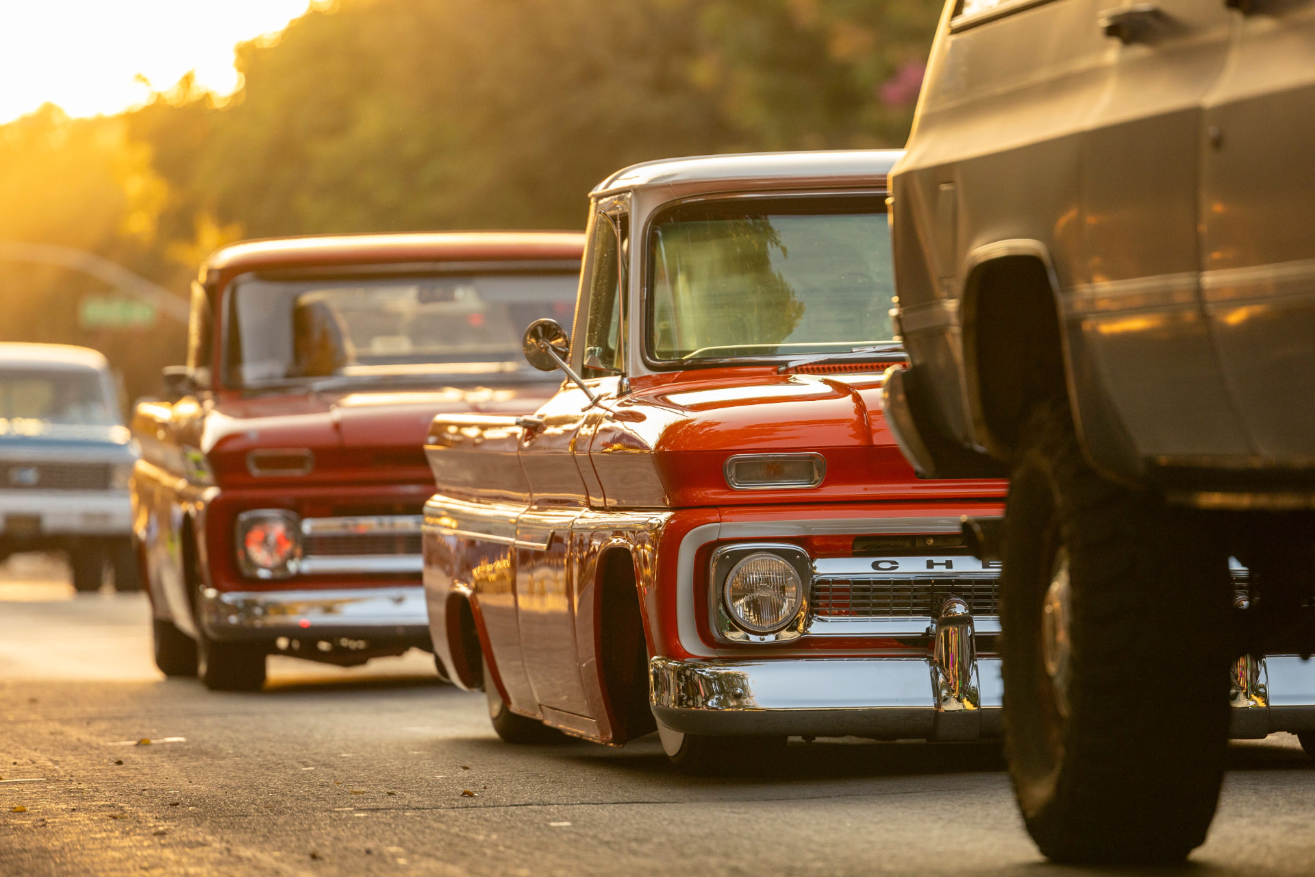 Classic Chevy pickup trucks lined up at sunset after detailing